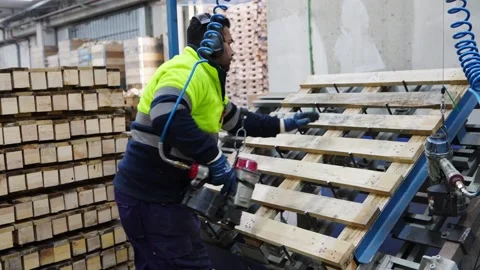 Carpenter assembling wooden pallets in slow motion Stock Footage 313918003