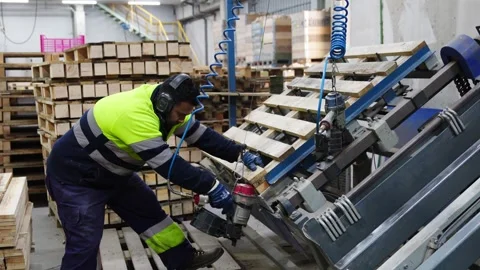 Carpenter assembling wooden pallets in slow motion Stock Footage 313918004