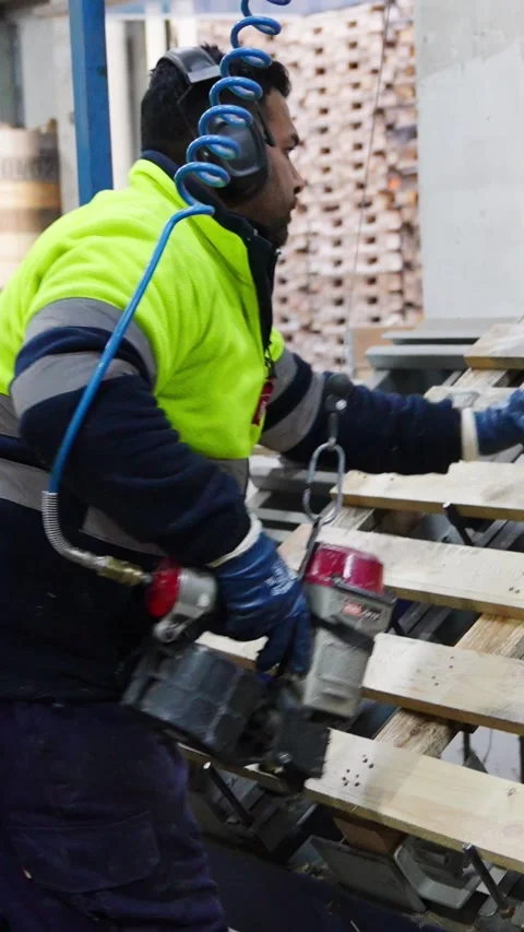 Carpenter assembling wooden pallets in slow motion Stock Footage 313924384