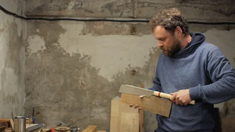 A carpenter with a beard and mustache saws a wooden element and damages a finger Stock Footage 105638132