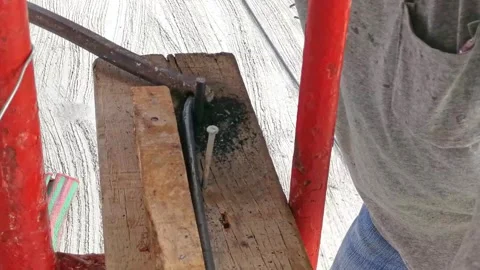 A carpenter is bending rebar into curves using special equipment to create .. Stock Footage 300072361