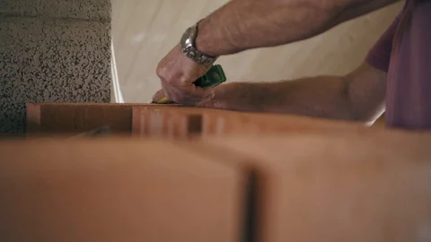 Carpenter builder is using a mesure roulette to measure a red brick fireplace. A Stock Footage 90087867
