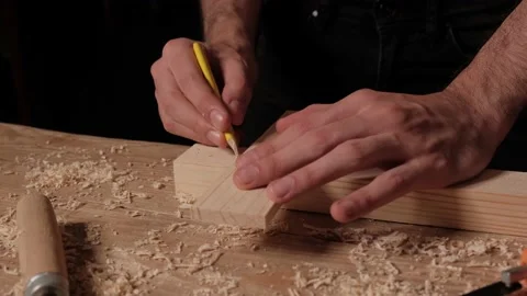 A carpenter in a carpentry workshop takes measurements and draws a close-up on Stock Footage 138458387