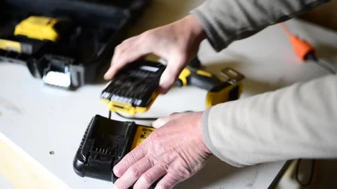 Carpenter charging Dewalt lithium-ion battery Stock Footage 241926951