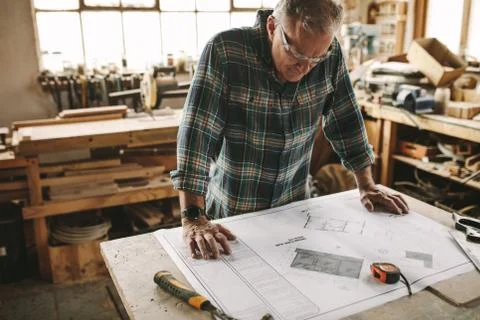 Carpenter checking the building plans before starting Fotos de archivo