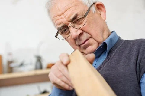 Carpenter checking the sharp edges of a wood Stock Photos