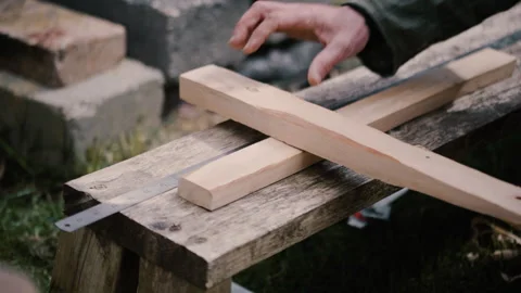 Carpenter checks size of two cross beams on hand made cross, slow motion Stock Footage 271196643