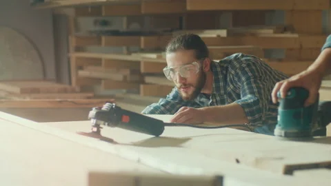 Carpenter Checks Smooth of the Product Another Carpenter Working Sanding Machine Video stock 224169425