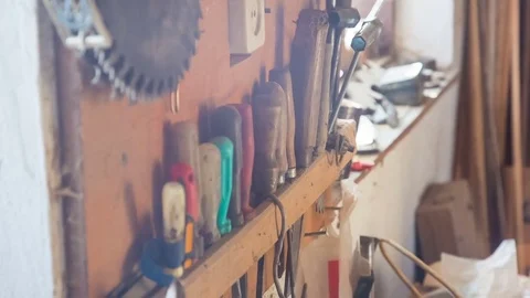 The carpenter chooses a chisel from the stand. The old bit is covered with dust Stockbeeldmateriaal 84452672