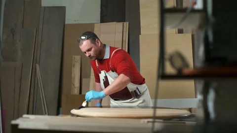 Carpenter coloring the table with black dye in the workshop slow motion Video stock 74496983