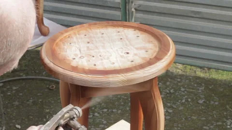Carpenter is covering stool by lacquer Stock Footage 63319241