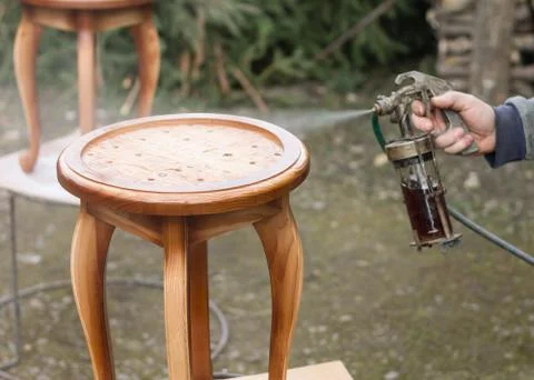 Carpenter is covering stool by lacquer Stock Photos