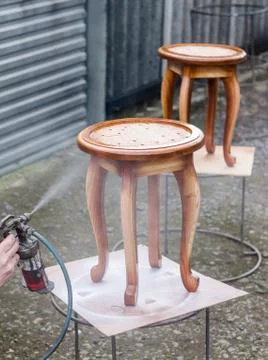 Carpenter is covering stool by lacquer Stock Photos