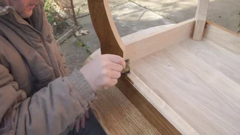 Carpenter is covering table by lacquer Stock Footage 69224730