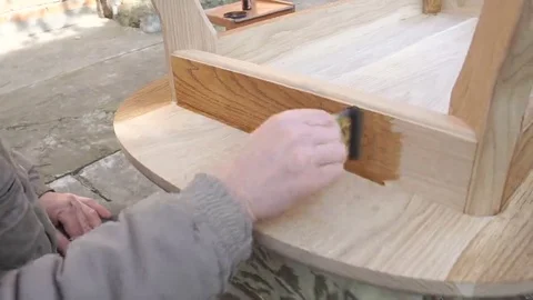 Carpenter is covering table by lacquer Stock Footage 69224907