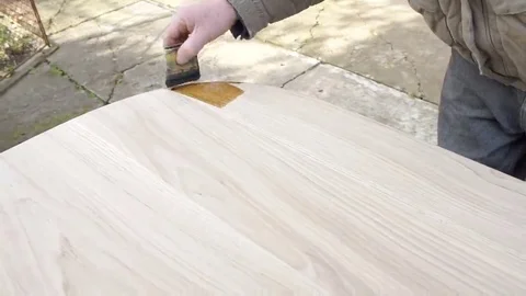 Carpenter is covering table by lacquer Stock Footage 69225295