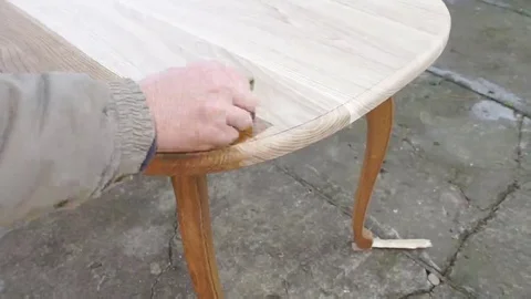 Carpenter is covering table by lacquer Stock Footage 69225307