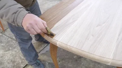 Carpenter is covering table by lacquer Stock Footage 69225326