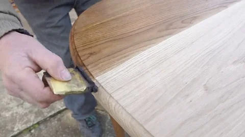 Carpenter is covering table by lacquer Stock Footage 69225333