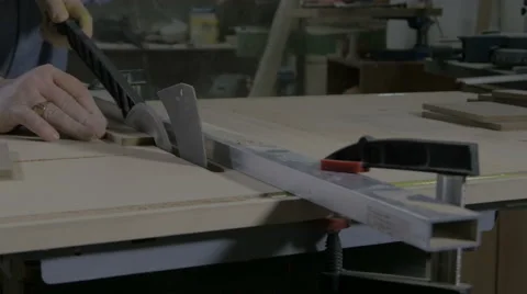Carpenter cuts board on electric circular table saw by stops, machine close up. Stock Footage 57740578