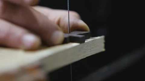 Carpenter cuts an ebony cross with a hand-held jigsaw.Orthodox cross. Saw sound. Stock Footage 146572447