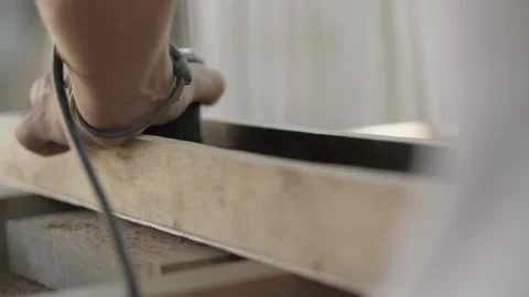 A carpenter cuts an old walnut wood plank with an electric hand-held fraser Stock Footage 137149946