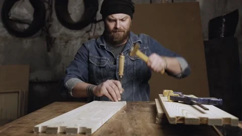 A carpenter cuts out a dovetail on a pine board with a chisel. dovetail joine Stock Footage 166340927