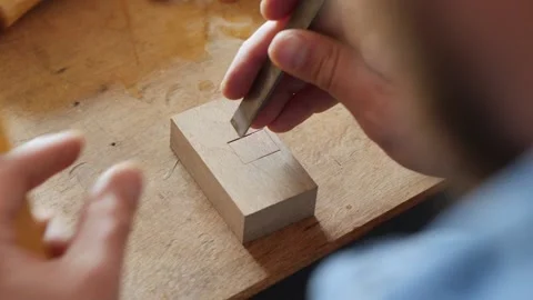 A carpenter cuts a square hole on the board with a chisel. hand carpentry tools Stock Footage 156683513