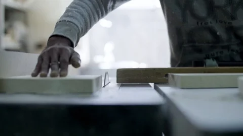 A carpenter cuts a wood plank using an electric saw Stock Footage 122029433