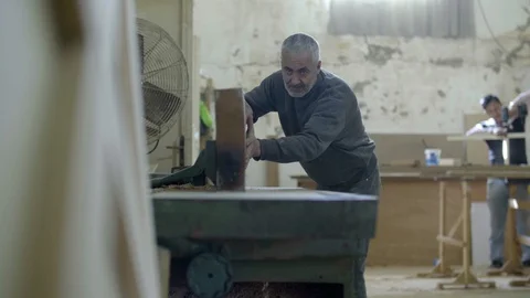 A carpenter cuts a wood plank using an electric saw Stock Footage 122062195
