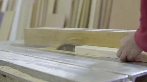 A carpenter cuts a wood plank using an electric saw Stock Footage 133282563