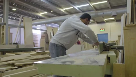 A carpenter cuts wood plank using an electric machine Stock Footage 141164838