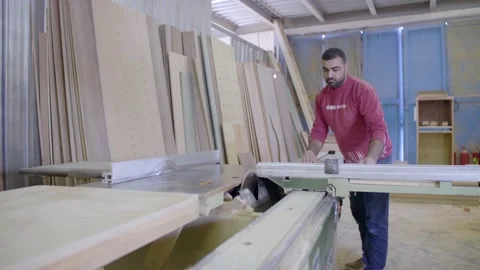 A carpenter cuts a wood plank using an electric saw, slow motion Stock Footage 141164889