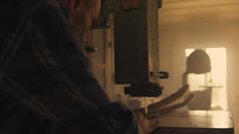 Carpenter cutting bark of wood on table saw in workshop Stock Footage 275632077