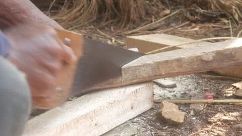 A carpenter is cutting a block of wood using a manual Stock Footage 333346635