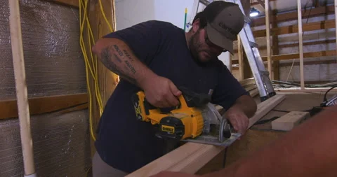 Carpenter Cutting Framing Lumber with Circular Saw Stock Footage 342838419