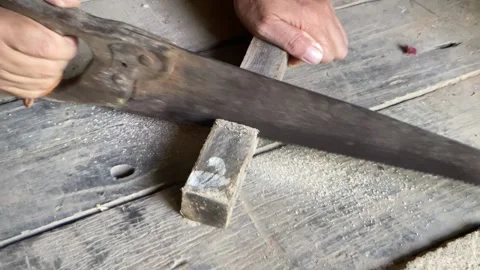 Carpenter cutting lumber with a hand saw. Stock Footage 278903696