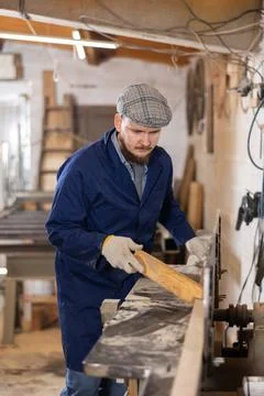 Carpenter cutting oak board with circular saw at sawmill Foto stock