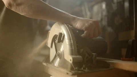 Carpenter cutting a piece of wood with a circular saw Stock Footage 148538522