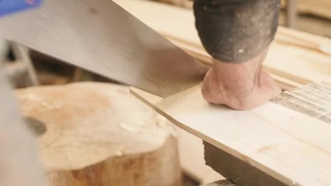 Carpenter cutting plank using handsaw Stockbeeldmateriaal 345724968