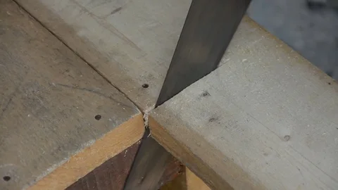 Carpenter cutting a slat of wood using a saw Stock Footage 83792313
