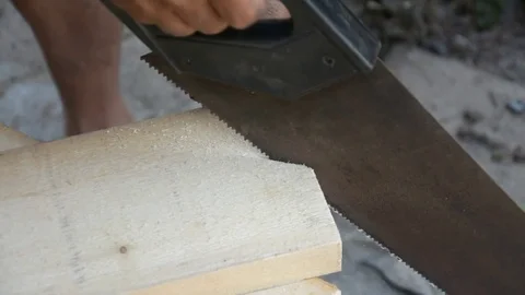 Carpenter cutting a slat of wood using a saw Stock Footage 83792397
