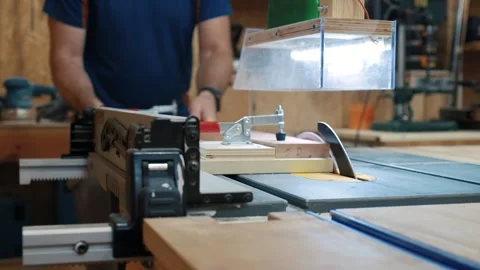Carpenter cutting wooden plank using table saw in his workshop 動画素材 314045297