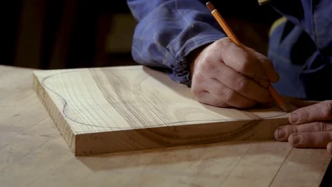 Carpenter draws a sketch of the shape of the cutting Board on a piece of wood Vidéo 100744620