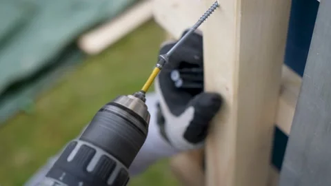Carpenter driling a screw with a dewalt drill Stock Footage 235789741