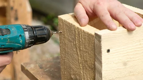 Carpenter drilling wood using portable drilling machine. Stock Footage 107923916