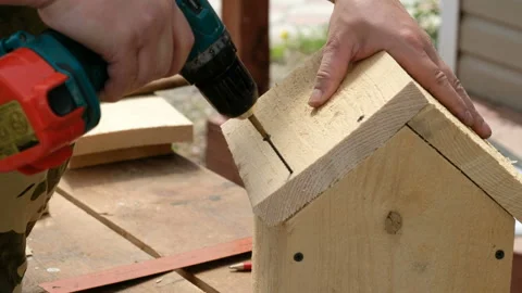 Carpenter drilling wood using portable drilling machine. Battery screwdriver or Vidéo 108140105