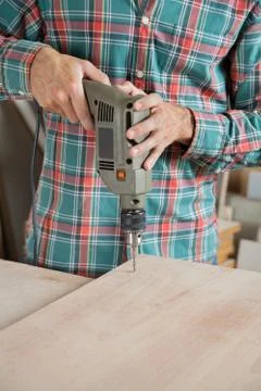 Carpenter Drilling Wood At Workbench In Workshop 스톡 사진