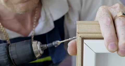 Carpenter Drills Hole For Screw. Assembling Wooden Furniture. Close-up Drill Stock Footage 134332702