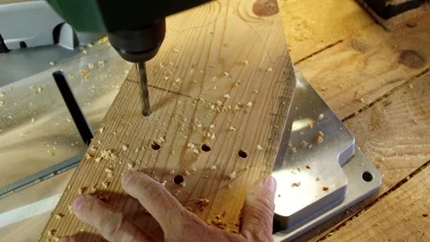 Carpenter drills through pine wood in workshop for precise hole making Stock Footage 321389828